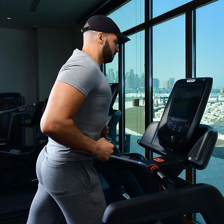 Mina Hotel And Residences By The Torch ドーハ エクステリア 写真 A man exercising on a treadmill