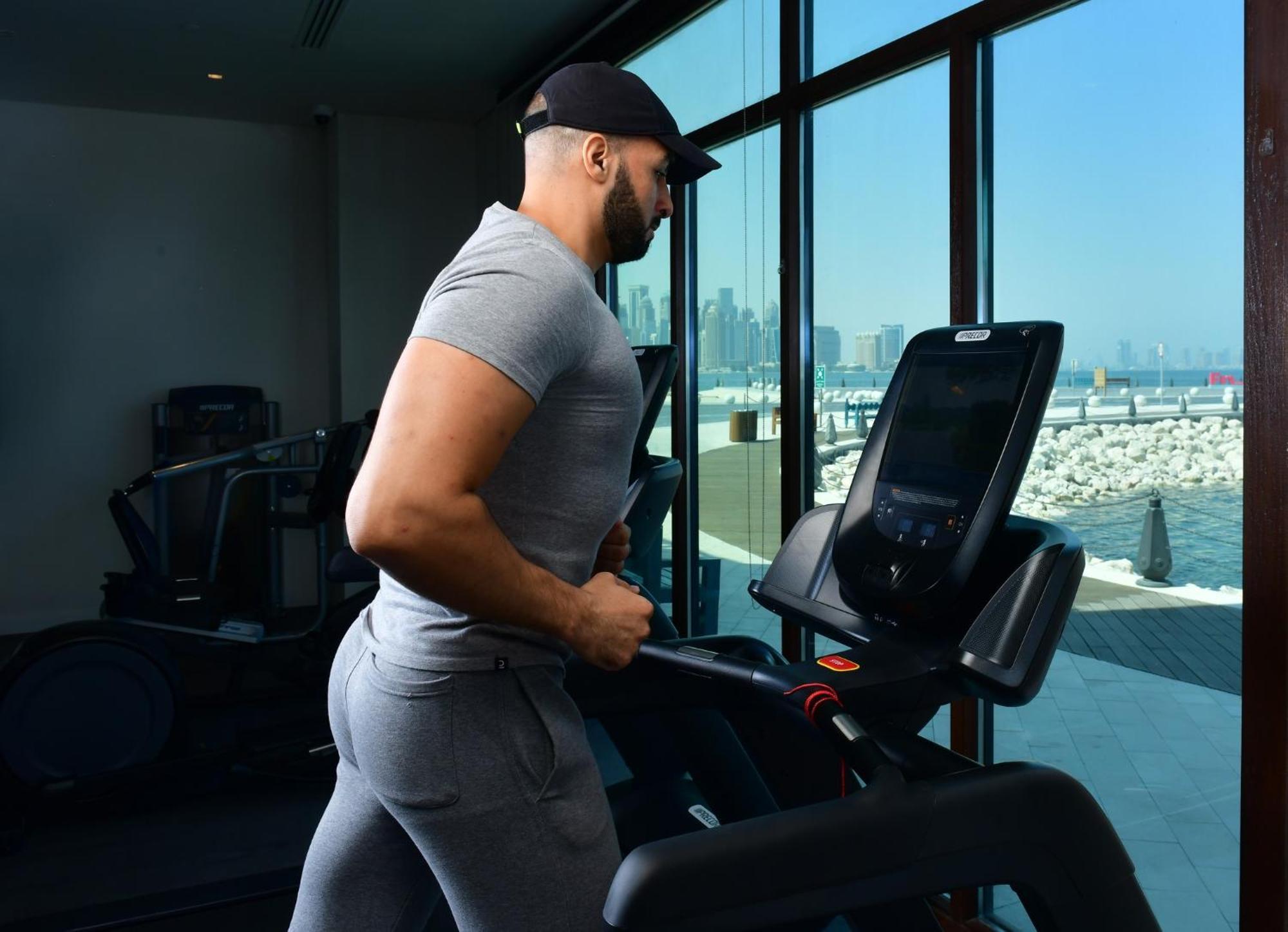 Mina Hotel And Residences By The Torch ドーハ エクステリア 写真 A man exercising on a treadmill
